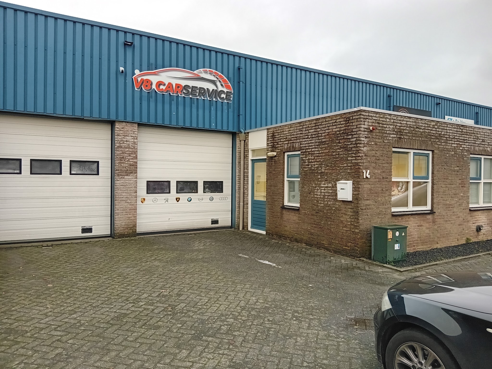 Het bedrijfspand van V8 Car Service met blauwe gevel en bord, De Kiel 14 in Drachten